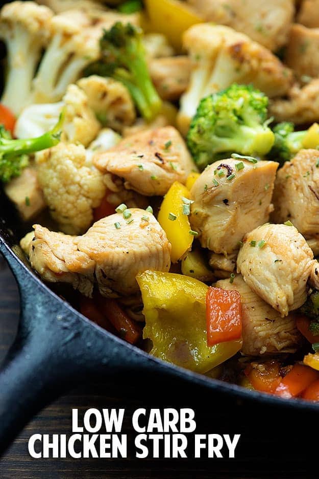 Close up picture of cooked chicken stir fry in cast iron skillet.