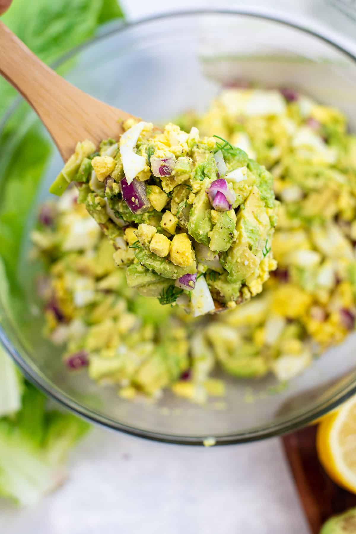 egg salad on wooden spoon.