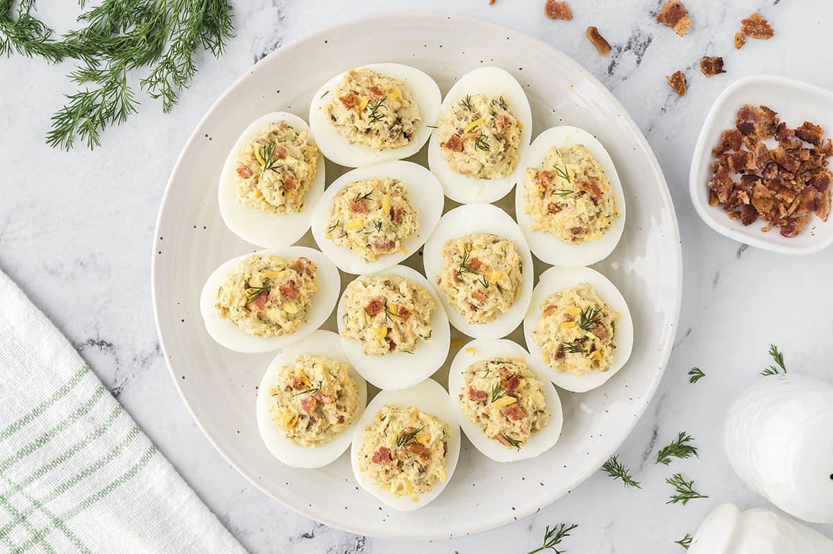 deviled egg recipe with bacon on cutting board