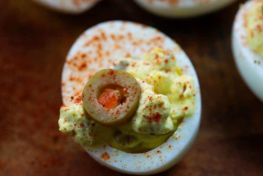 deviled egg recipe with green olives on cutting board
