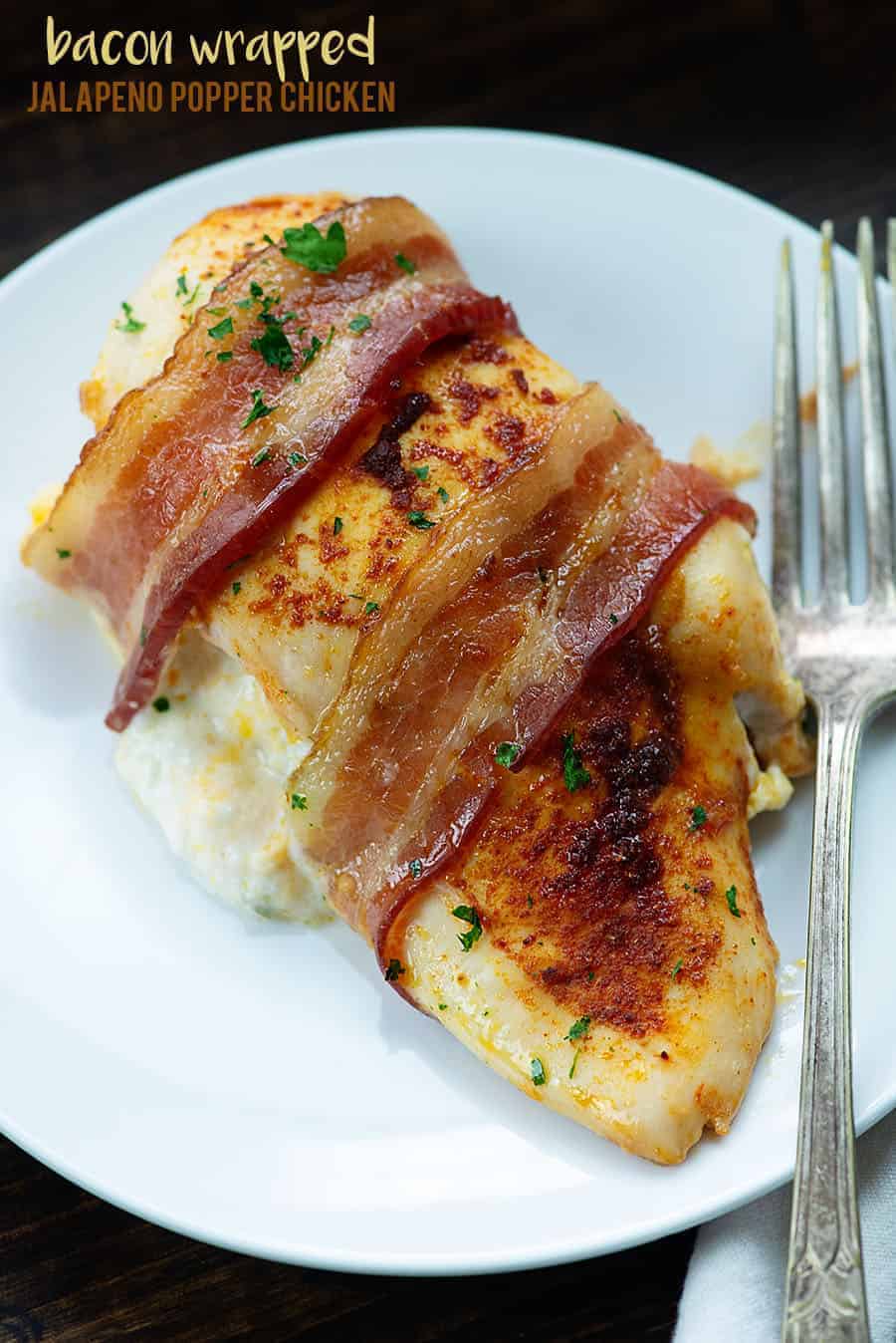 stuffed chicken wrapped in bacon on white plate