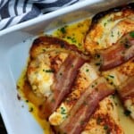 chicken wrapped in bacon in white baking dish