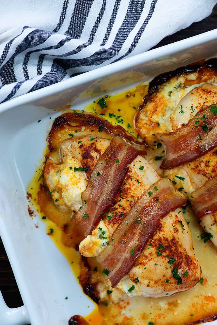 chicken wrapped in bacon in white baking dish