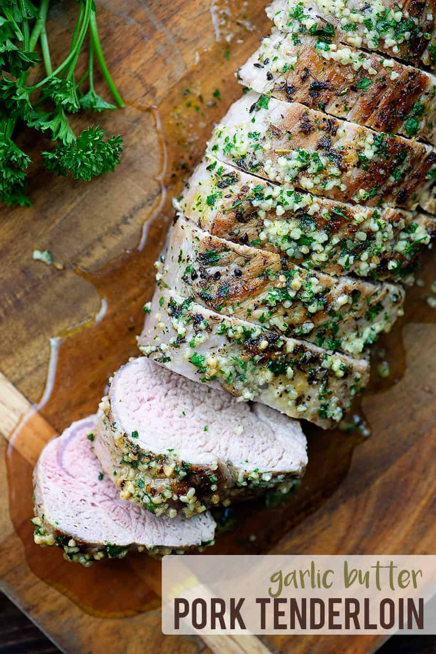 Juicy garlic butter tenderloin cut up on cutting board.