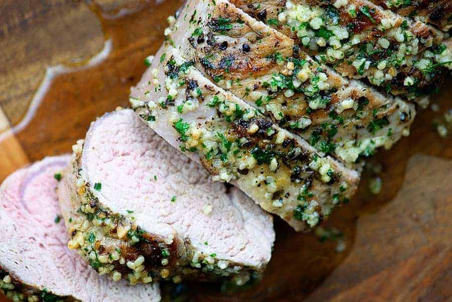 sliced pork tenderloin on wood cutting board