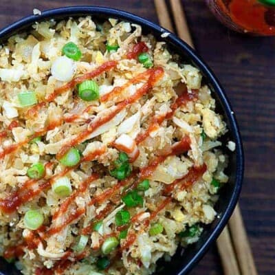 chicken fried cauliflower rice in black bowl