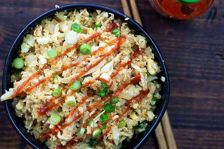 chicken fried cauliflower rice in black bowl