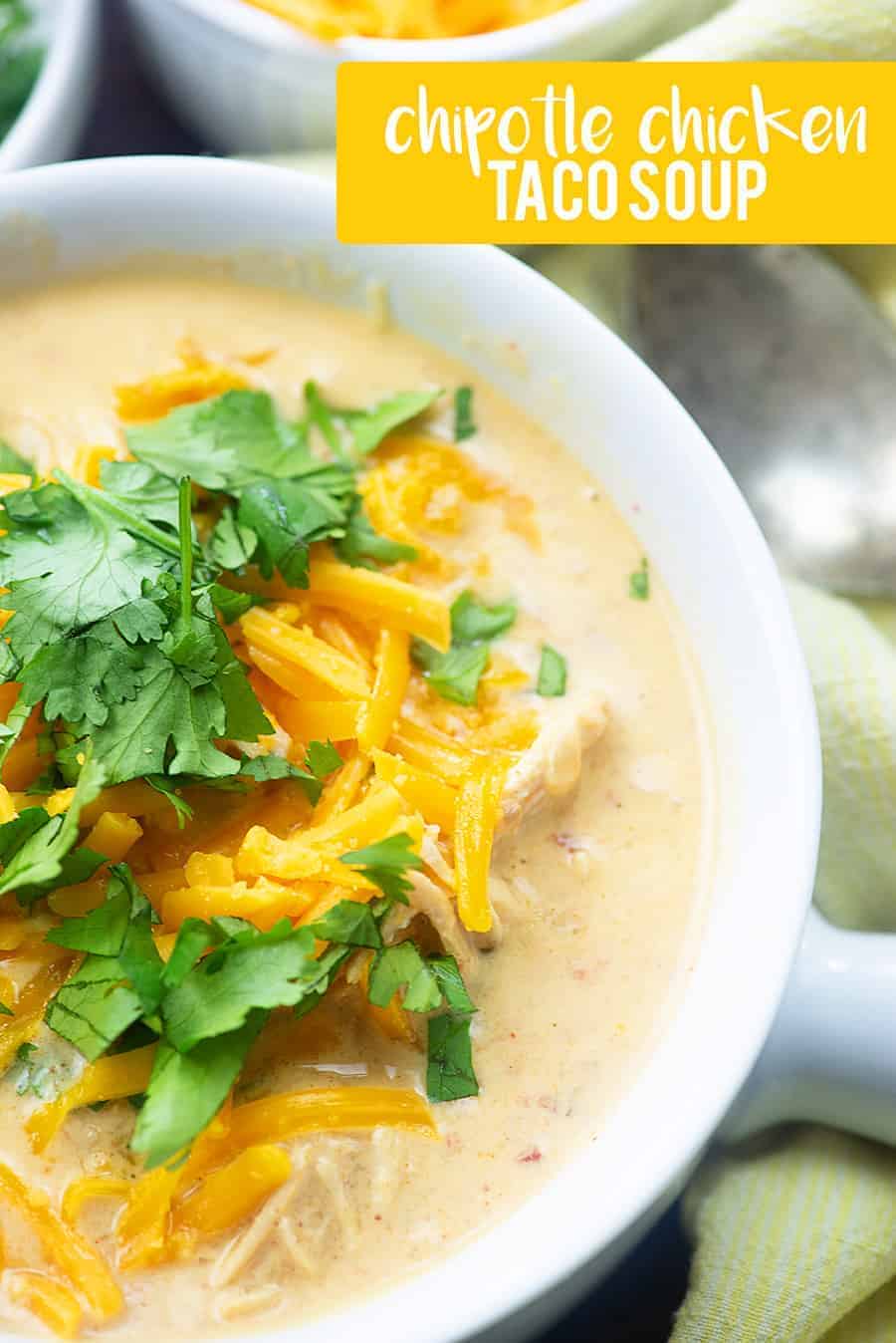 Taco soup in a white bowl with a handle.