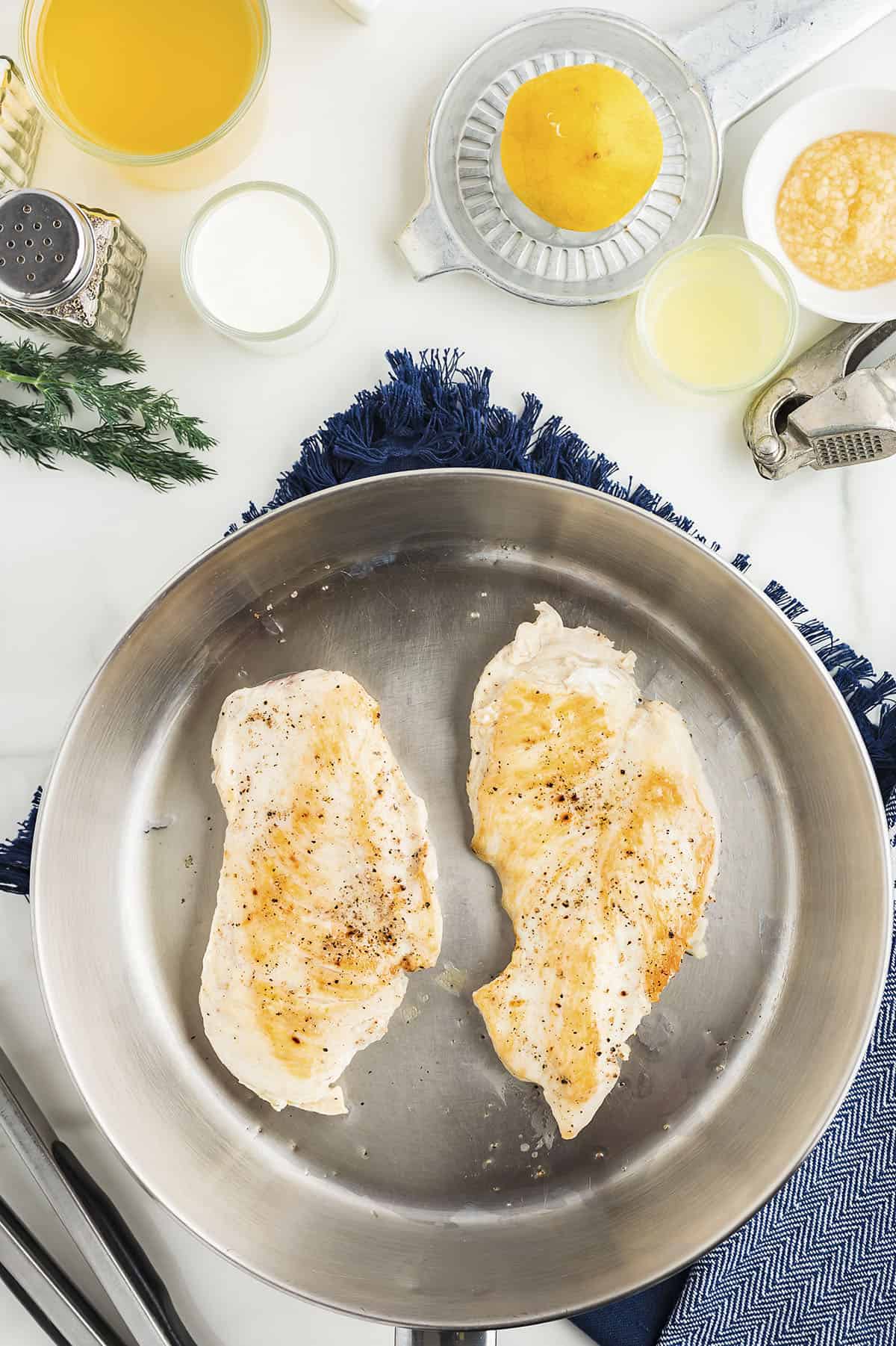 Chicken breasts cooked in skillet.