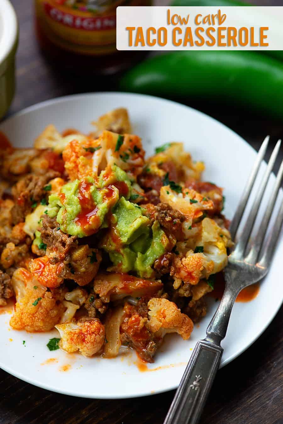 Taco casserole on small white plate with a fork.