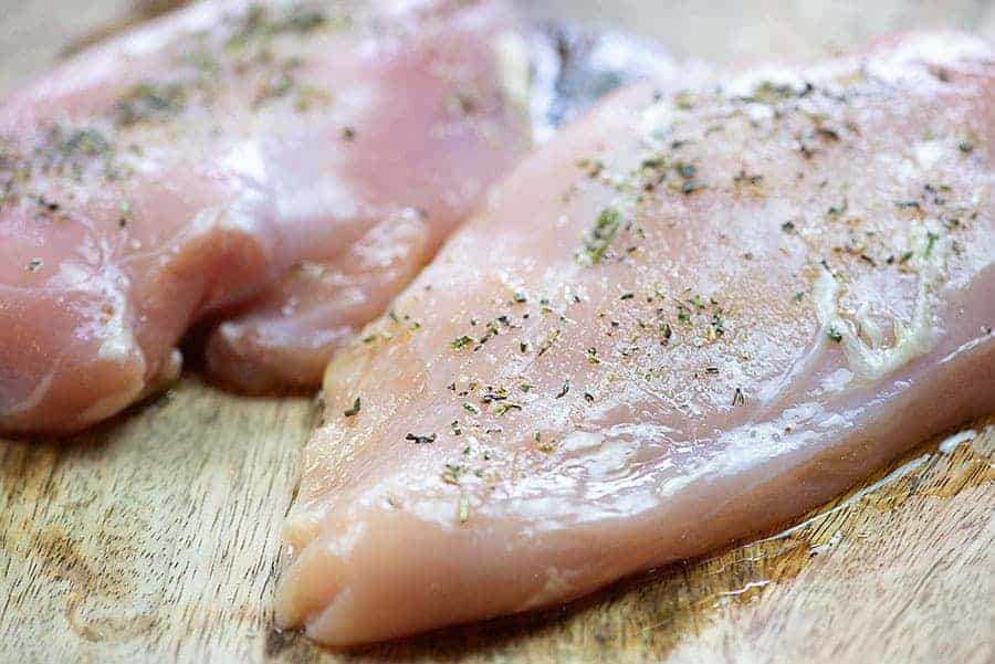 seasoned chicken breasts on cutting board