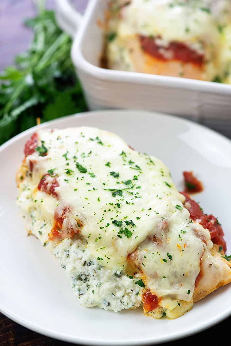 cooked lasagna stuffed chicken on small white plate