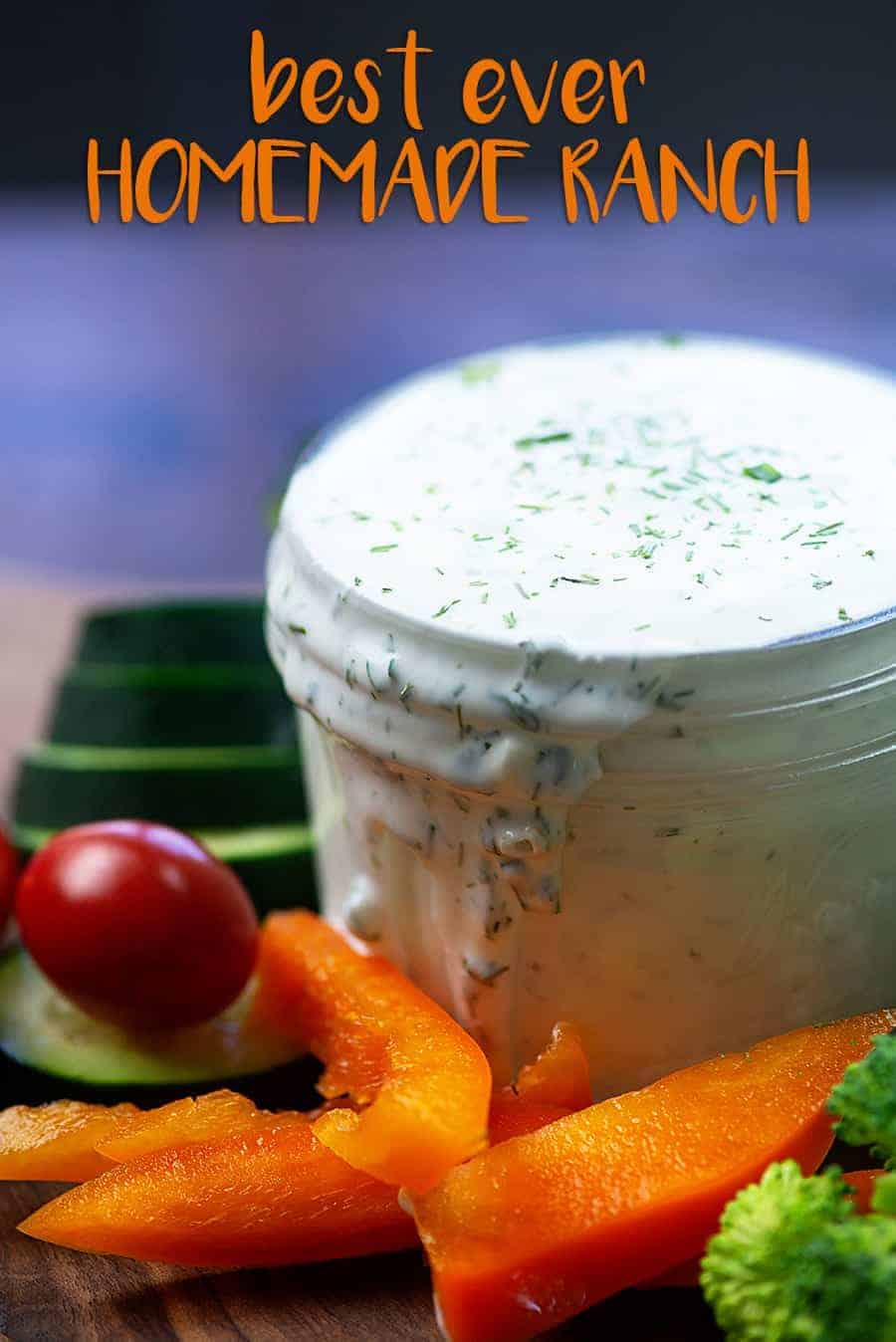 A jar of ranch dressing surrounded by various vegetables