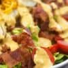 Closeup of salad topped with bacon and thousand island dressing