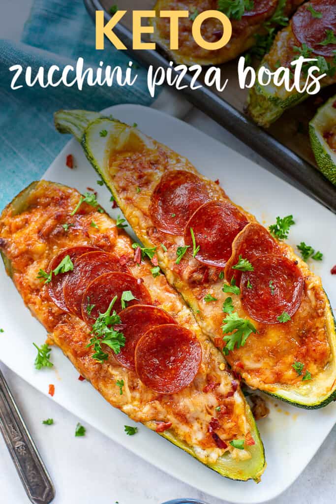 zucchini stuffed with pizza toppings on white plate.