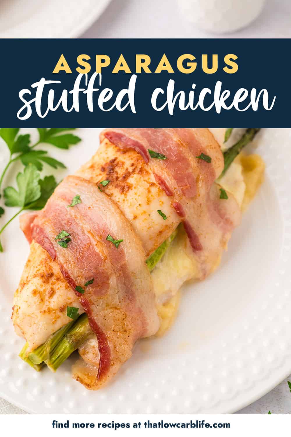 chicken stuffed with asparagus and wrapped in bacon on white plate