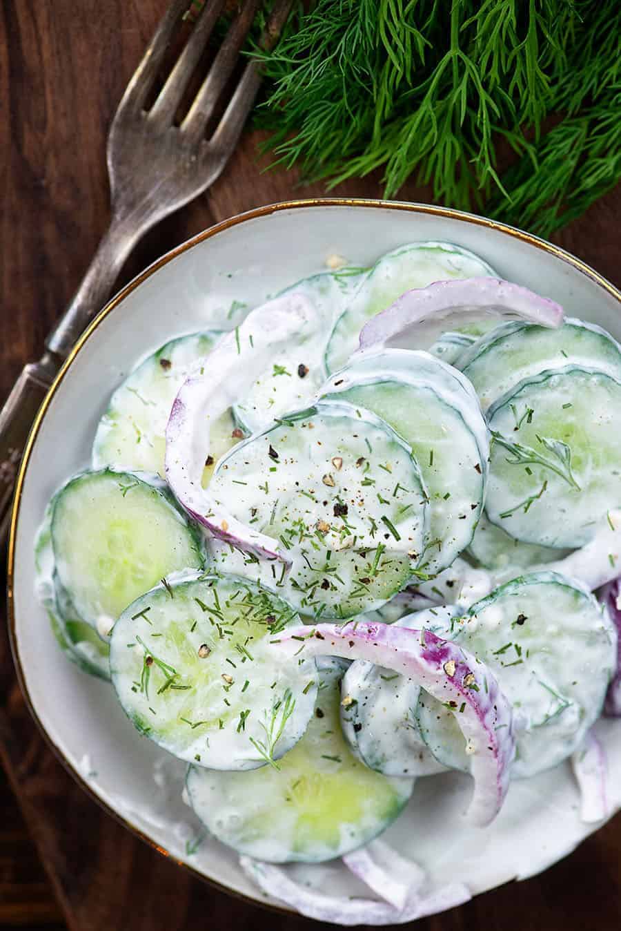 cucumber salad on white plate with a fork
