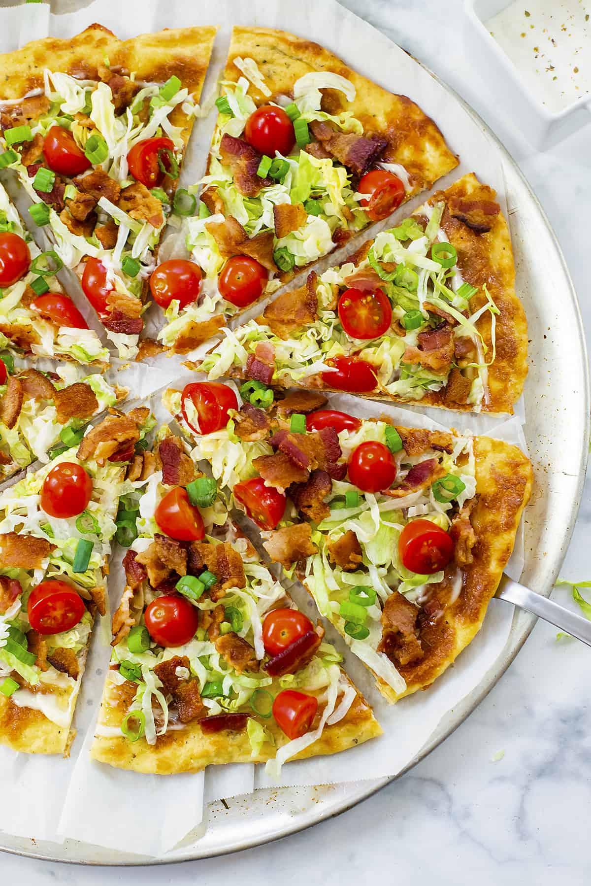 Overhead view of BLT pizza on pizza pan.