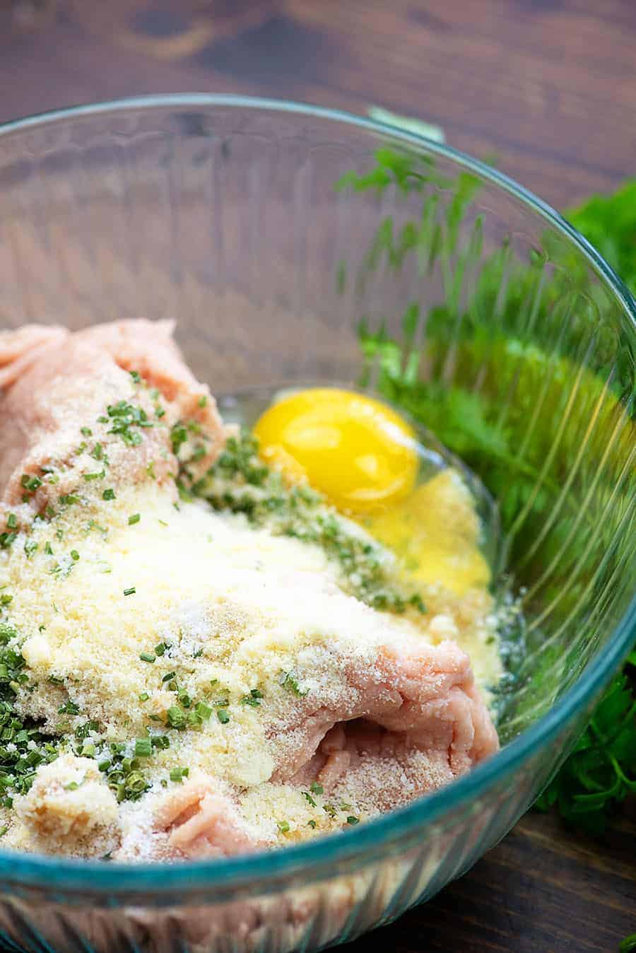 Buffalo chicken meatball ingredients in glass mixing bowl.