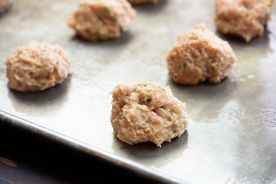 Buffalo chicken meatballs shaped on a sheet pan.