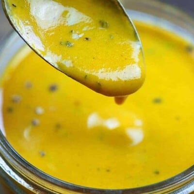 Spoon dripping sauce into a jar