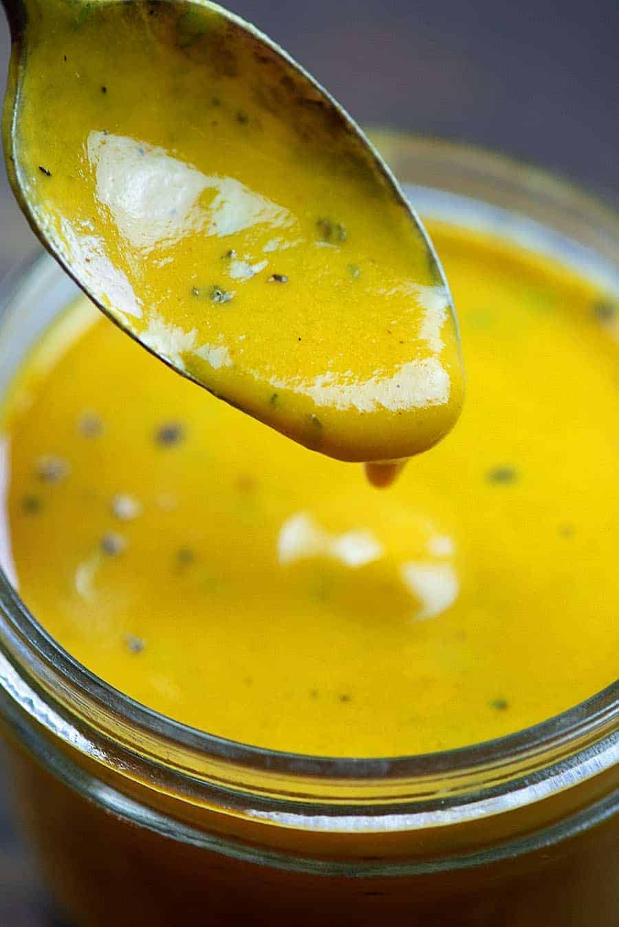 Spoon dripping sauce into a jar