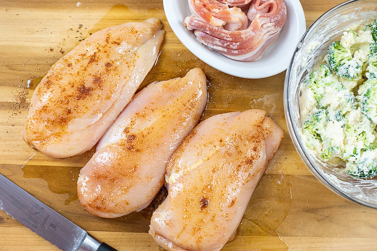 seasoned chicken breasts on cutting board.