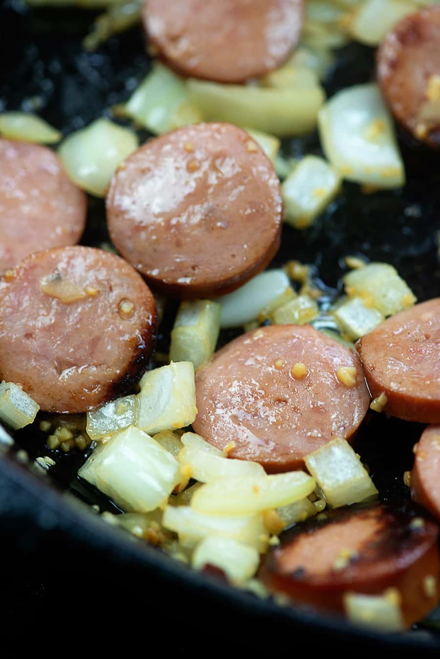 onions, garlic, and sausage in cast iron skillet