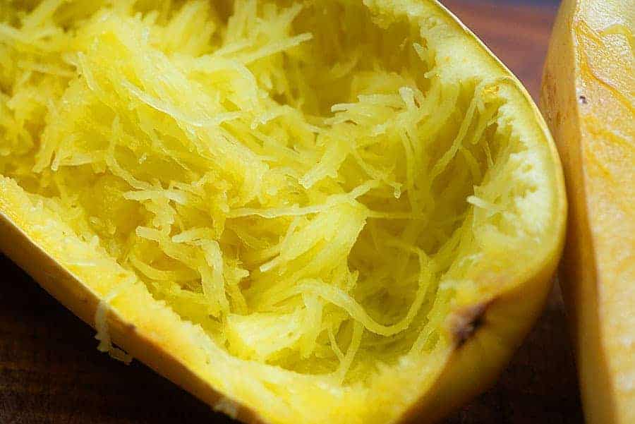 shredded squash in a squash that has been sliced in half