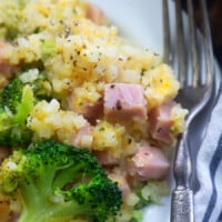ham broccoli and cauliflower on a white plate with a fork on the side