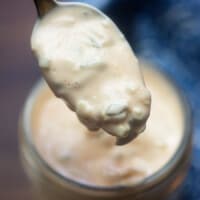 spoon full of thousand island dressing over a jar
