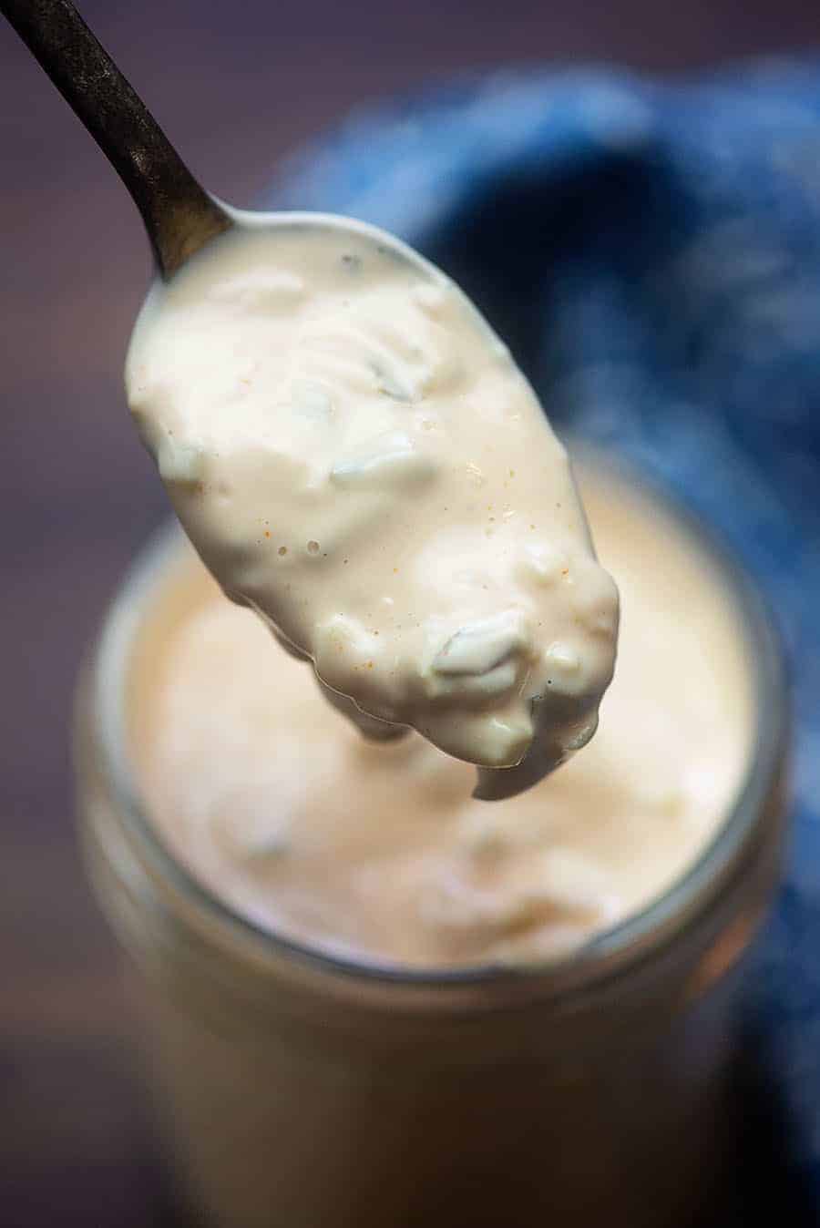scooping a spoonful of low carb dressing from a jar