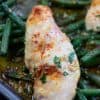 cooked chicken and green beans on a baking sheet