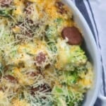 White oval baking pan with sliced sausages and cheese