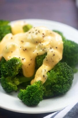 A plate of food with broccoli, with Cheese and Sauce