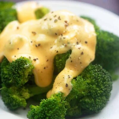 A plate of food with broccoli, with Cheese and Sauce