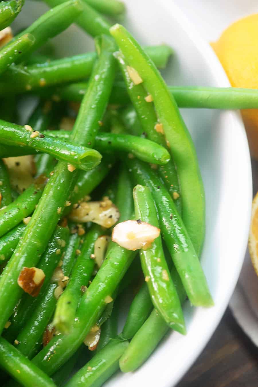 Green beans almondine in a large white bowl
