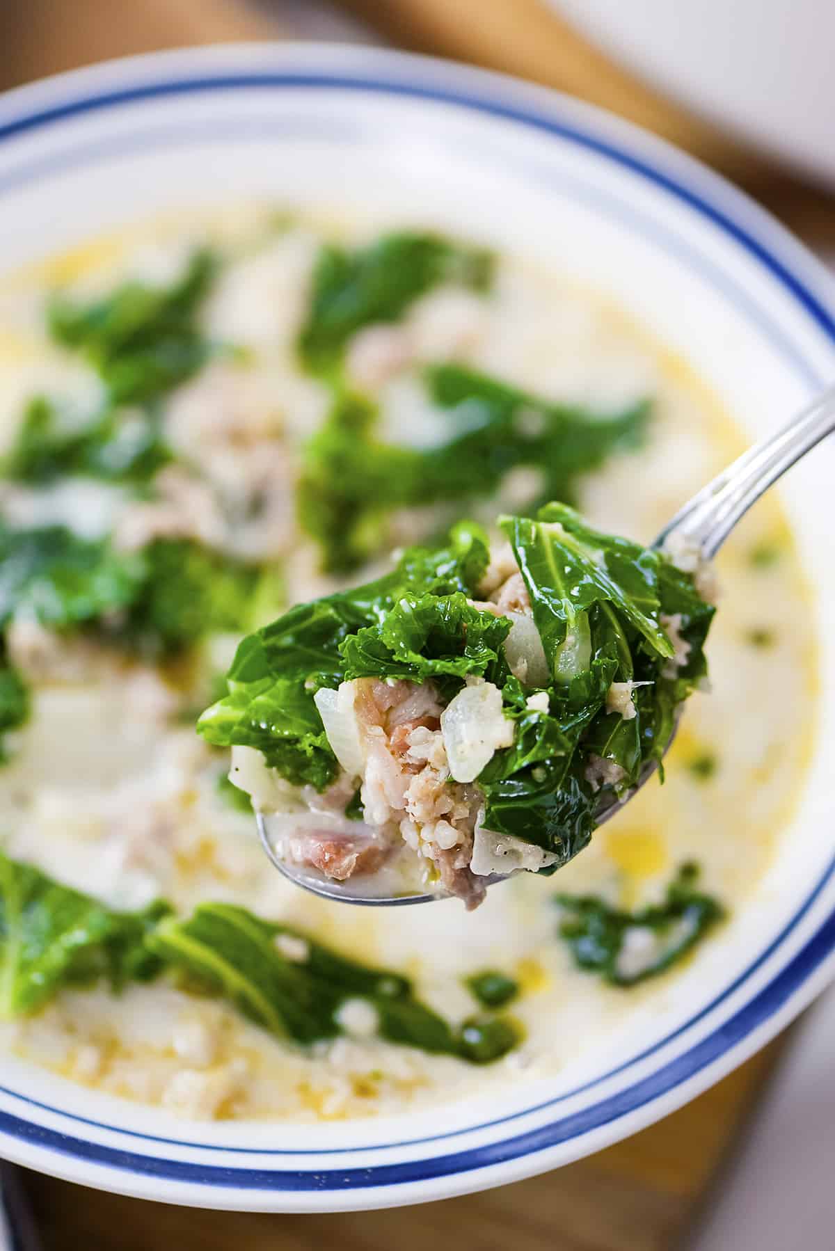 Bowl of zuppa toscana with a spoon.