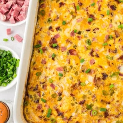 piece of casserole topped with chives and sour cream on a white plate