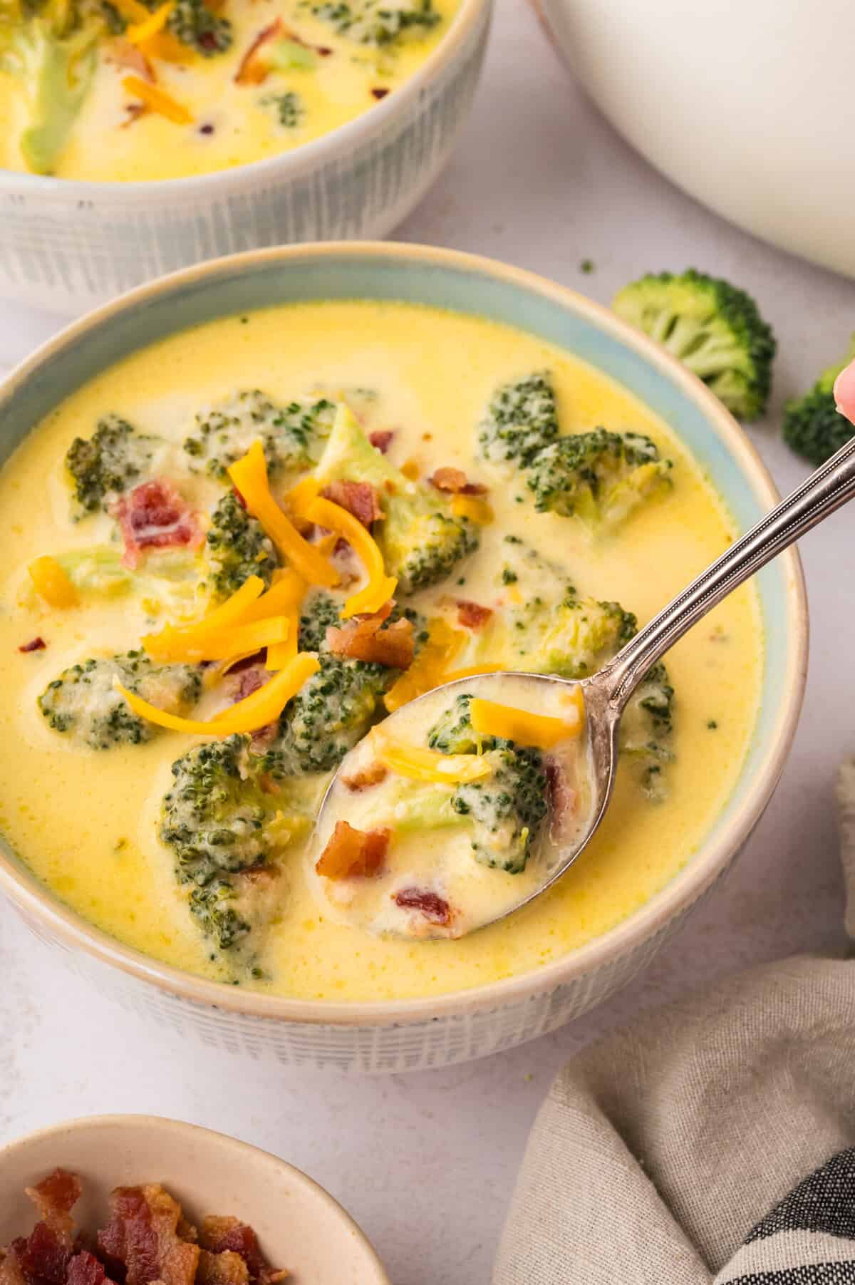 Broccoli cauliflower soup in bowl with spoon.