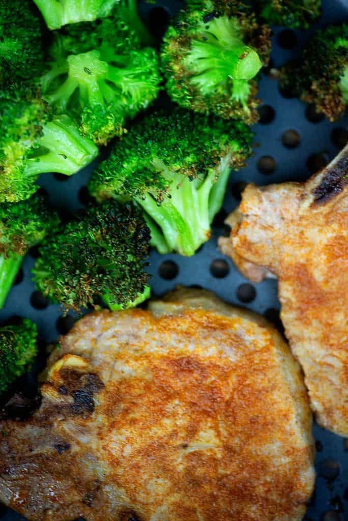 A plate of food with broccoli, with Pork chop