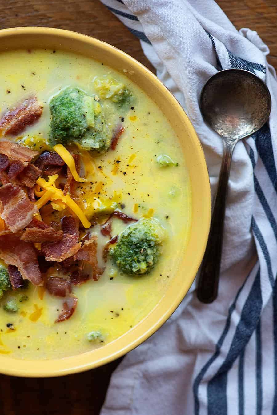 broccoli cauliflower soup in a bowl with an old spoon