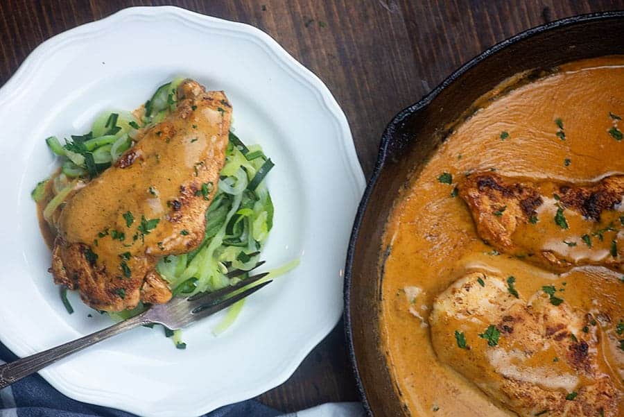 chicken lazone on a plate next to a cast iron skillet