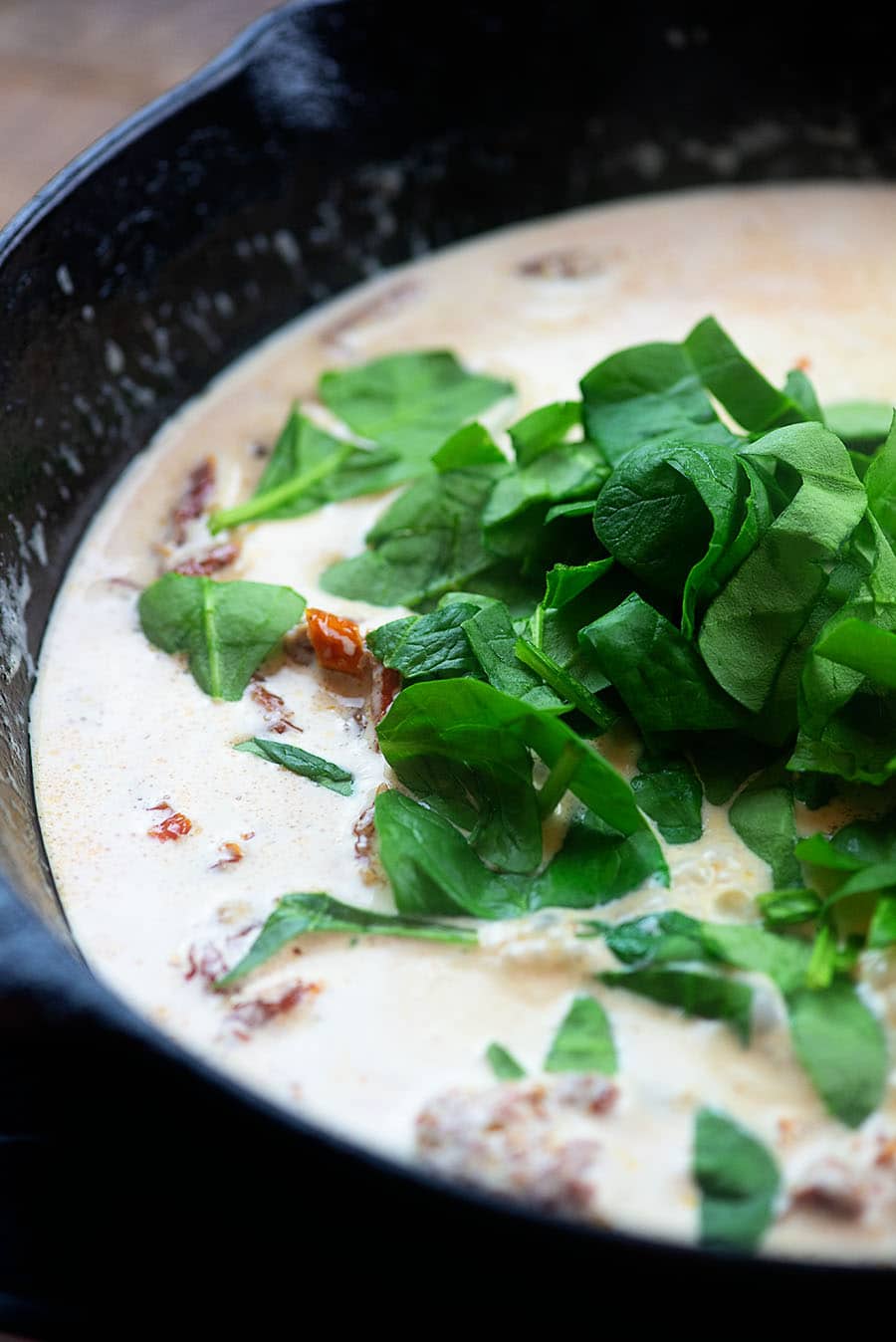 spinach and sauce in a cast iron skillet