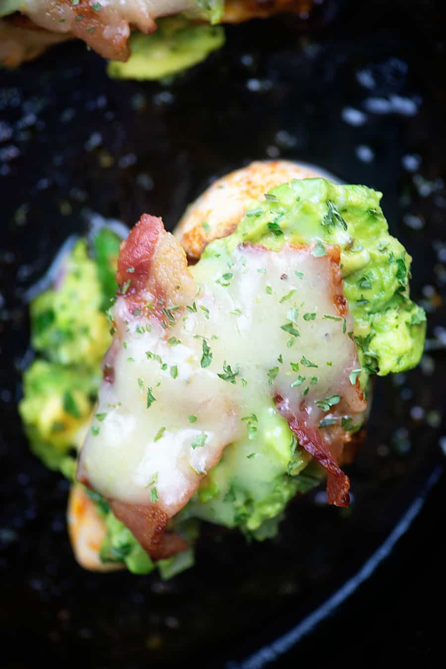 chicken searing in a cast iron skillet melting cheese