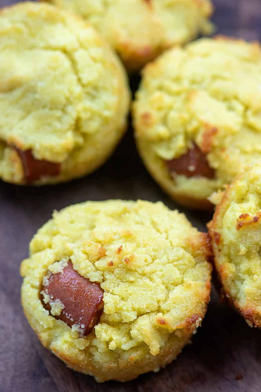 Five corn dog muffins on a wooden table