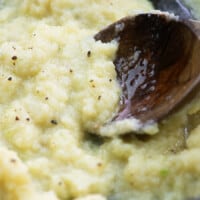 wooden spoon dipping into mashed cauliflower