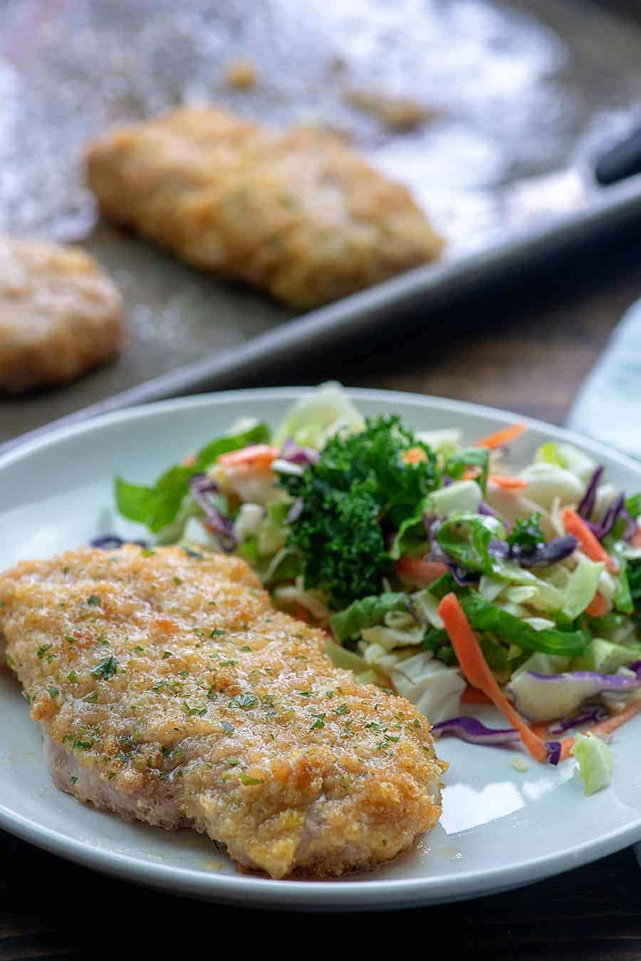 Côtes de porc et salade sur une assiette blanche