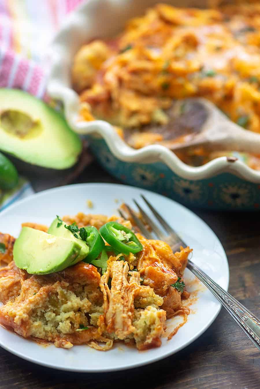 white plate and fork with chicken tamale and avacado