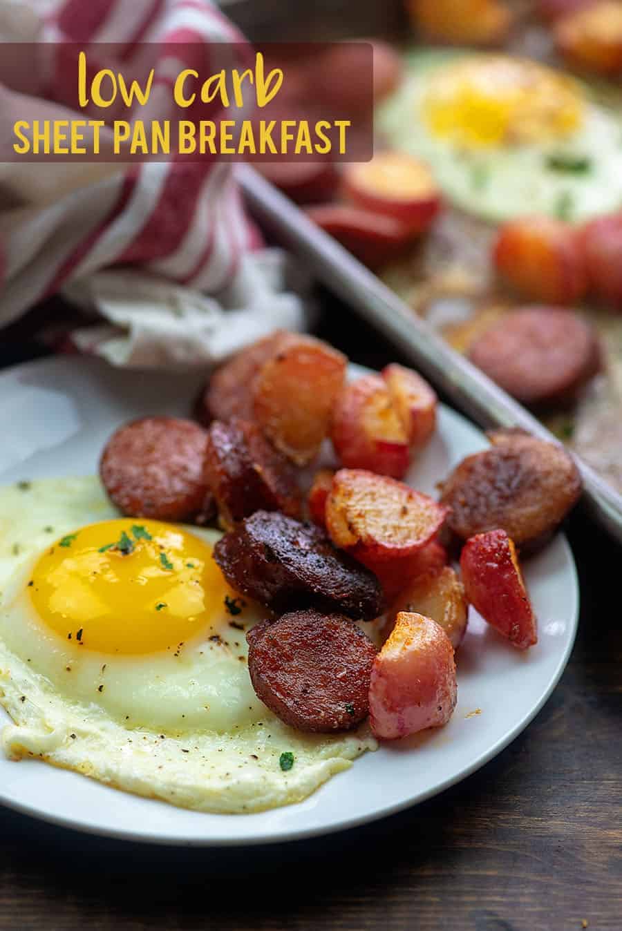 sausages and an egg on a white plate next to a baking sheet